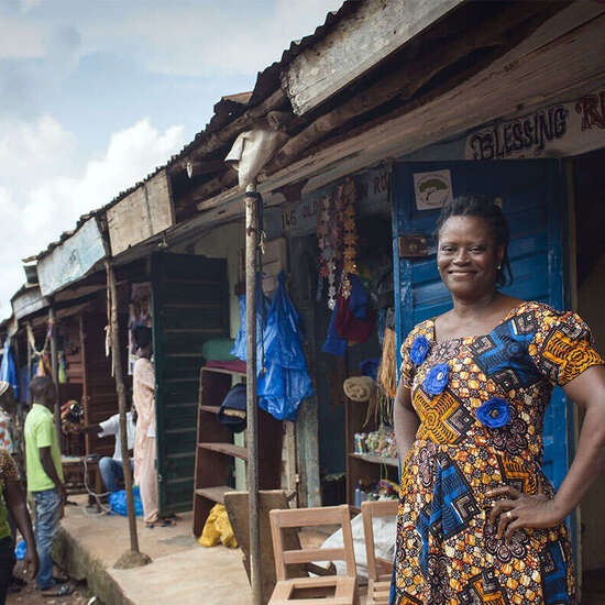 Frau vor ihrer Produktionsstätte für Recylingprodukte