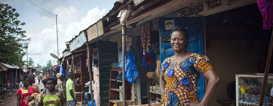 Frau vor ihrer Produktionsstätte für Recylingprodukte