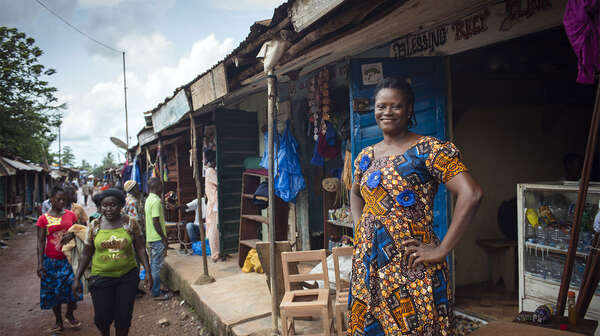 Frau vor ihrer Produktionsstätte für Recylingprodukte