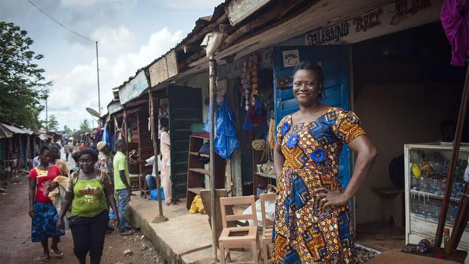 Frau vor ihrer Produktionsstätte für Recylingprodukte