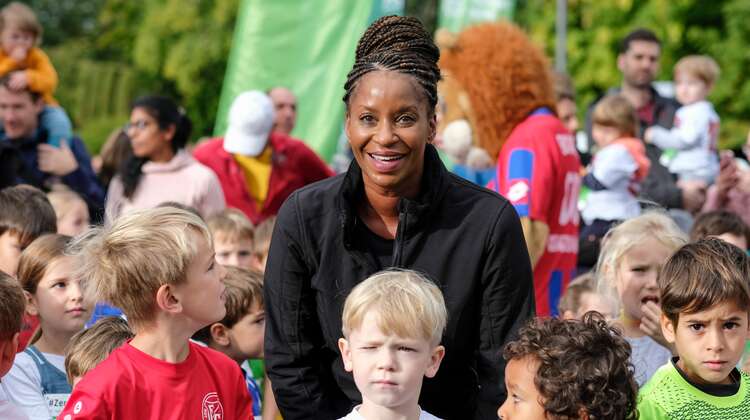 Liz Baffoe posiert mit teilnehmenden Kindern für die Kamera.