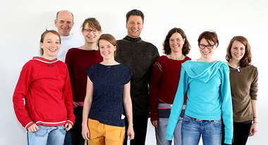 Sechs Frauen und zwei Männder der Welthungerhilfe tragen ihre Kleidung seitenverkehrt mit dem Label nach außen.Mitarbeiter machen mit beim Fashion Revolution Day.