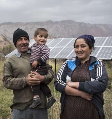Eine Familie vor ihrer Solaranlage in Tadschikistan.