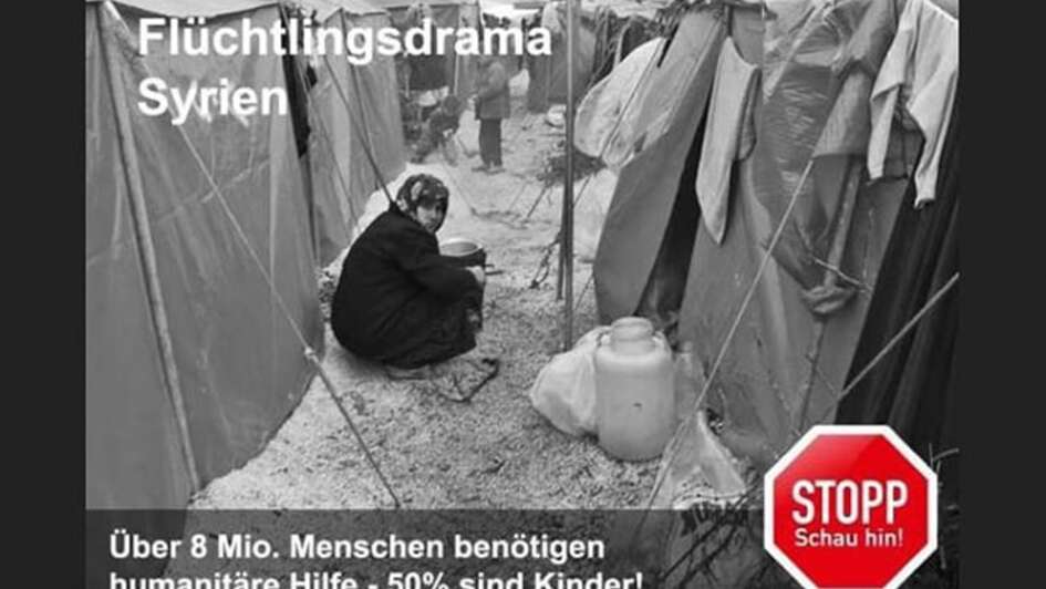 Eine Frau sitzt zwischen Zelten in einem Flüchtlingslager.