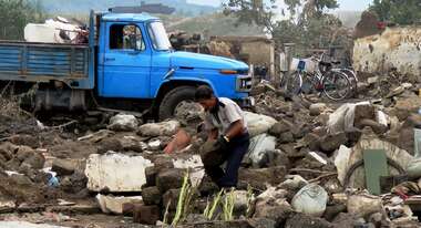 Ein Mann räumt Trümmer auf
