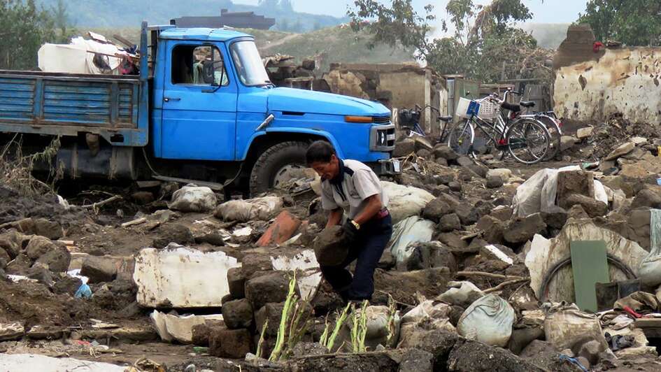 Ein Mann räumt Trümmer auf