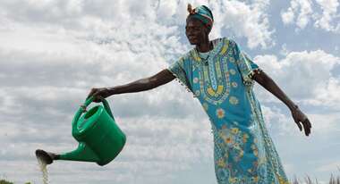 Eine Frau bewässert das Obst und Gemüse in dem schuleigenen Garten, Südsudan 2022.