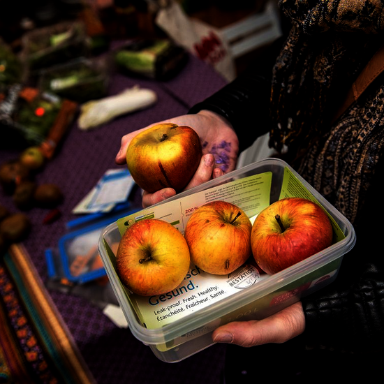 Lebensmittelverschwendung stoppen. Bild: Eine Frischhaltebox mit drei Äpfeln.