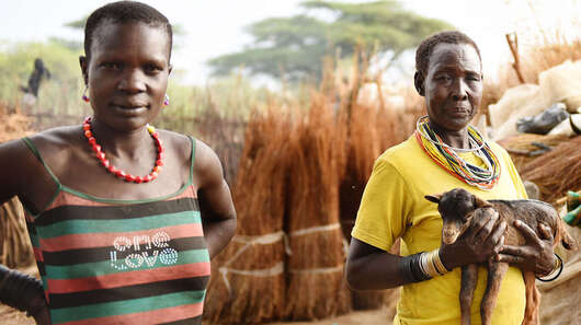 Eine Frau hält eine Ziege auf dem Arm in Moroto, Uganda.