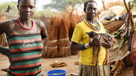 Eine Frau hält eine Ziege auf dem Arm in Moroto, Uganda.