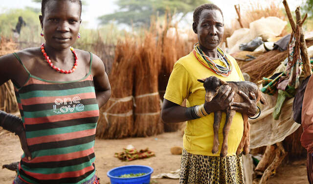 Eine Frau hält eine Ziege auf dem Arm in Moroto, Uganda.
