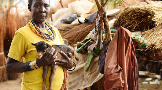 Eine Frau hält eine Ziege auf dem Arm in Moroto, Uganda.