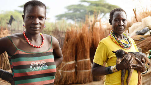 Eine Frau hält eine Ziege auf dem Arm in Moroto, Uganda.