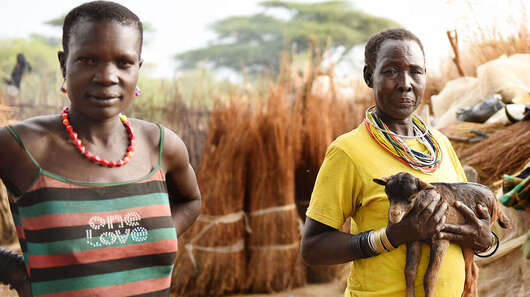 Eine Frau hält eine Ziege auf dem Arm in Moroto, Uganda.