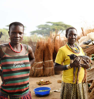 Eine Frau hält eine Ziege auf dem Arm in Moroto, Uganda.
