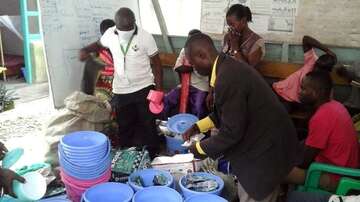 Ein Welthungerhilfe-Mitarbeiter verteilt Eimer und weitere Dinge zur Wasseraufbereitung