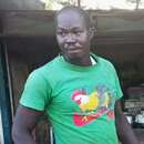 Ein Mann steht an einem Tisch, vor ihm liegen viele gerupfte Hühner.