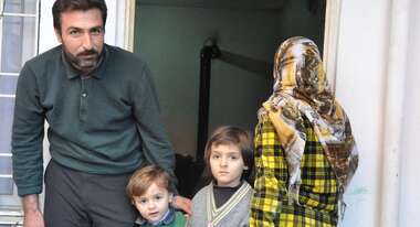Afafe und Khaled mit ihren Kindern vor einem Haus