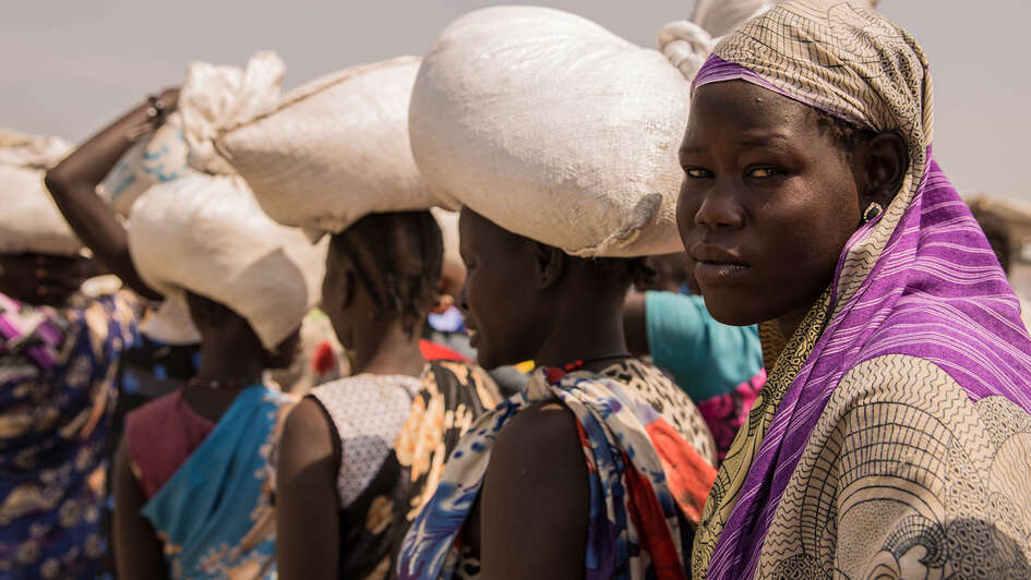Hungersnöte verhindern. Bild: Frauen bei einer Lebensmittelverteilung im Flüchtlingscamp Bentiu.
