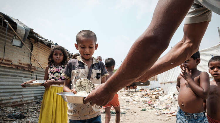Ein lachender Junge bei der Essensausgabe.