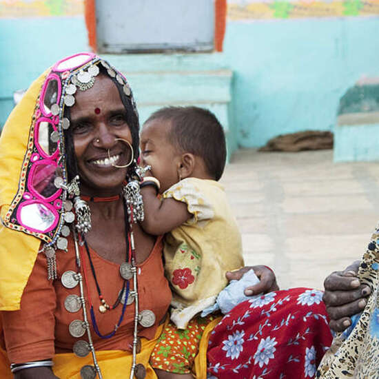 ältere Frauen in bunten Kleidern sitzen auf dem Boden