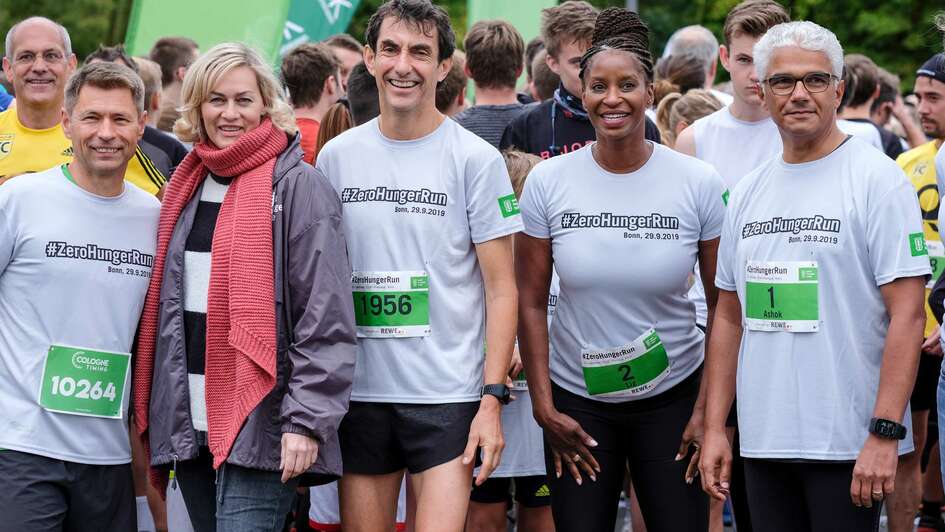 Fünf Menschen schauen lächelnd in die Kamera.