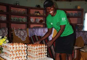 Fatima Gapa steht neben den Eiern, die ihre Hennen gelegt haben