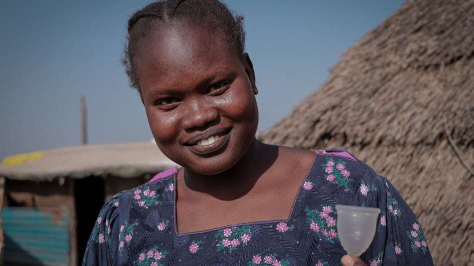 Eine junge Frau zeigt eine Menstruationstasse, Bentiu, Unity State, Südsudan Januar 2022. 