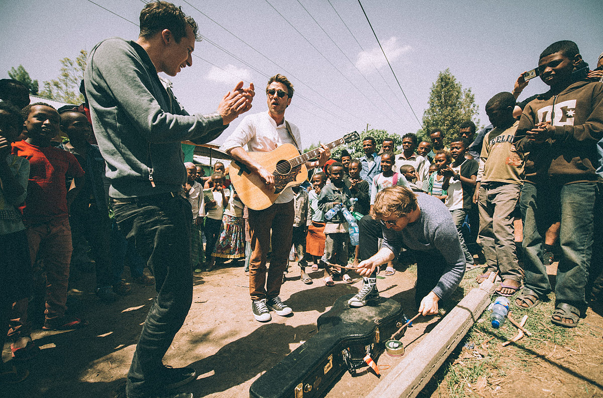 Clueso und zwei Gitarristen machen ihren ersten Halt auf der Strasse umgeben von neugierigen Zuhörern 